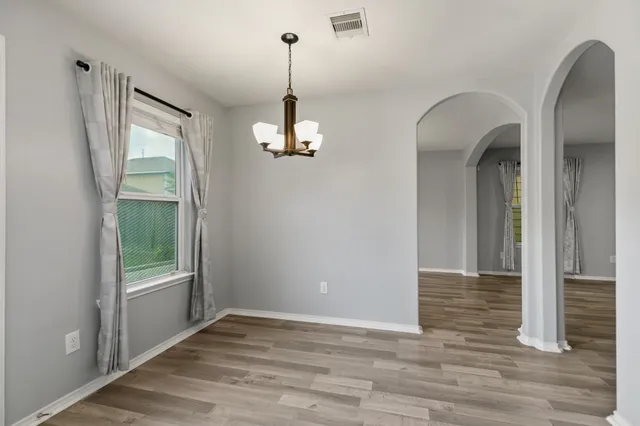a view of empty room with wooden floor