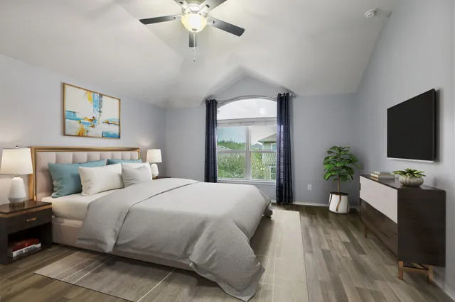a bedroom with a large bed and a flat tv screen on dresser