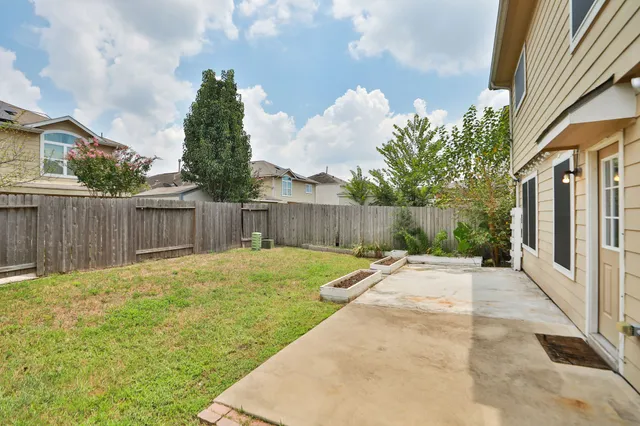a view of a backyard with wooden fence