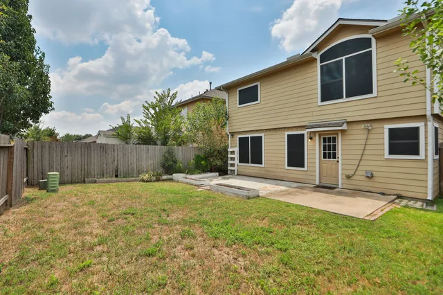 a backyard of a house with table and chairs