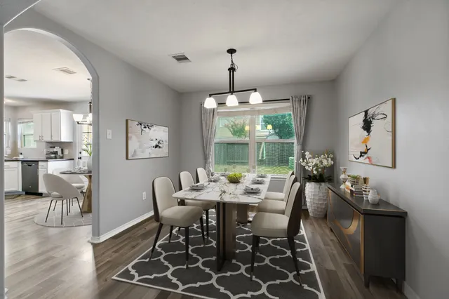 a dining room with furniture a chandelier and wooden floor
