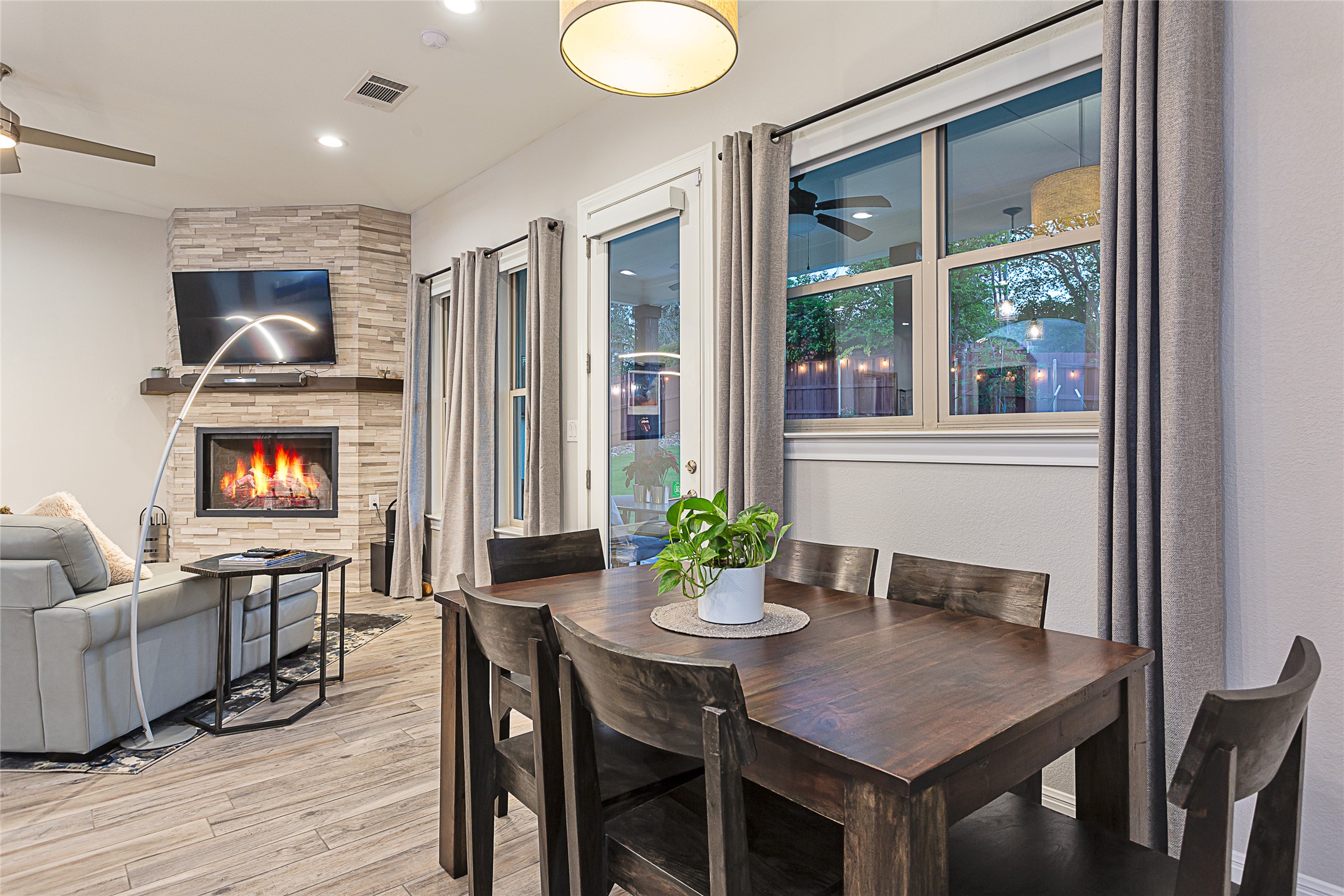 5608 Arroyo Road Austin, TX 78734 - Photo 17 of 39 Dining space with ceiling fan, a large fireplace, light wood-type flooring, and recessed lighting