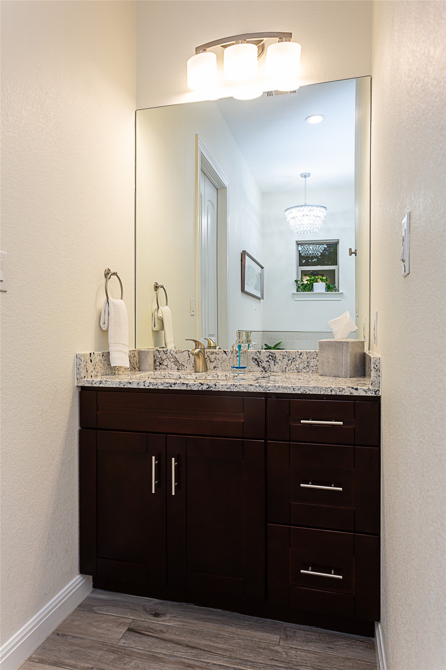 5608 Arroyo Road Austin, TX 78734 - Photo 25 of 39 Bathroom with a textured wall, vanity, and dark wood-style flooring