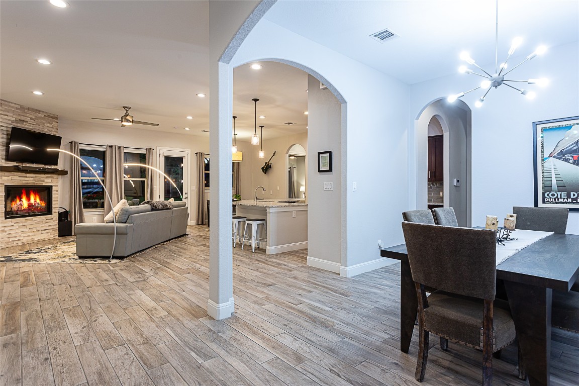 5608 Arroyo Road Austin, TX 78734 - Photo 3 of 39 Dining room with a chandelier, recessed lighting, ceiling fan, a fireplace, and light wood-style floors