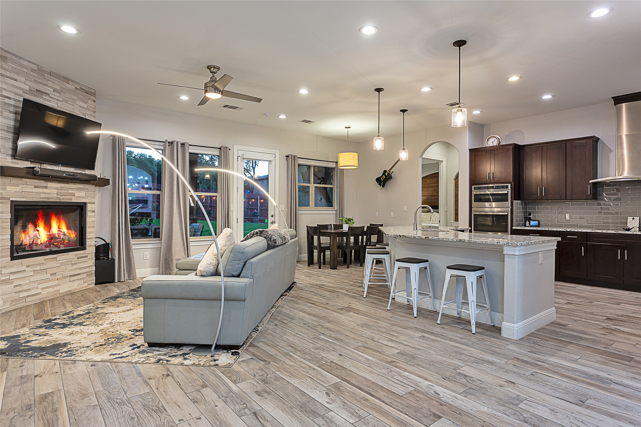 5608 Arroyo Road Austin, TX 78734 - Photo 6 of 39 Living room featuring ceiling fan, a stone fireplace, recessed lighting, light wood-type flooring, and arched walkways