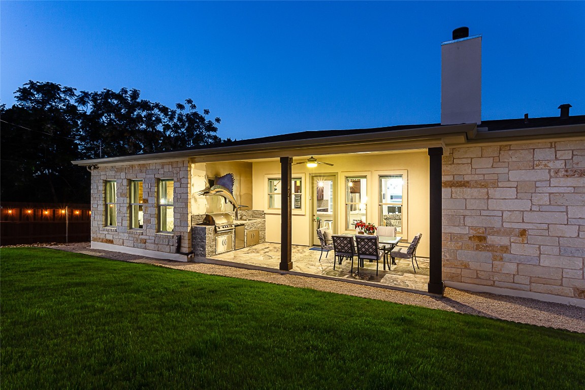 5608 Arroyo Road Austin, TX 78734 - Photo 7 of 39 Rear view of house with exterior kitchen, stone siding, a lawn, and a patio