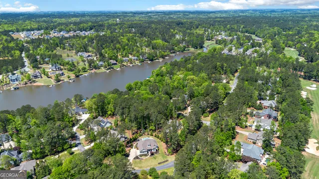 an aerial view of a houses with a yard and lake view