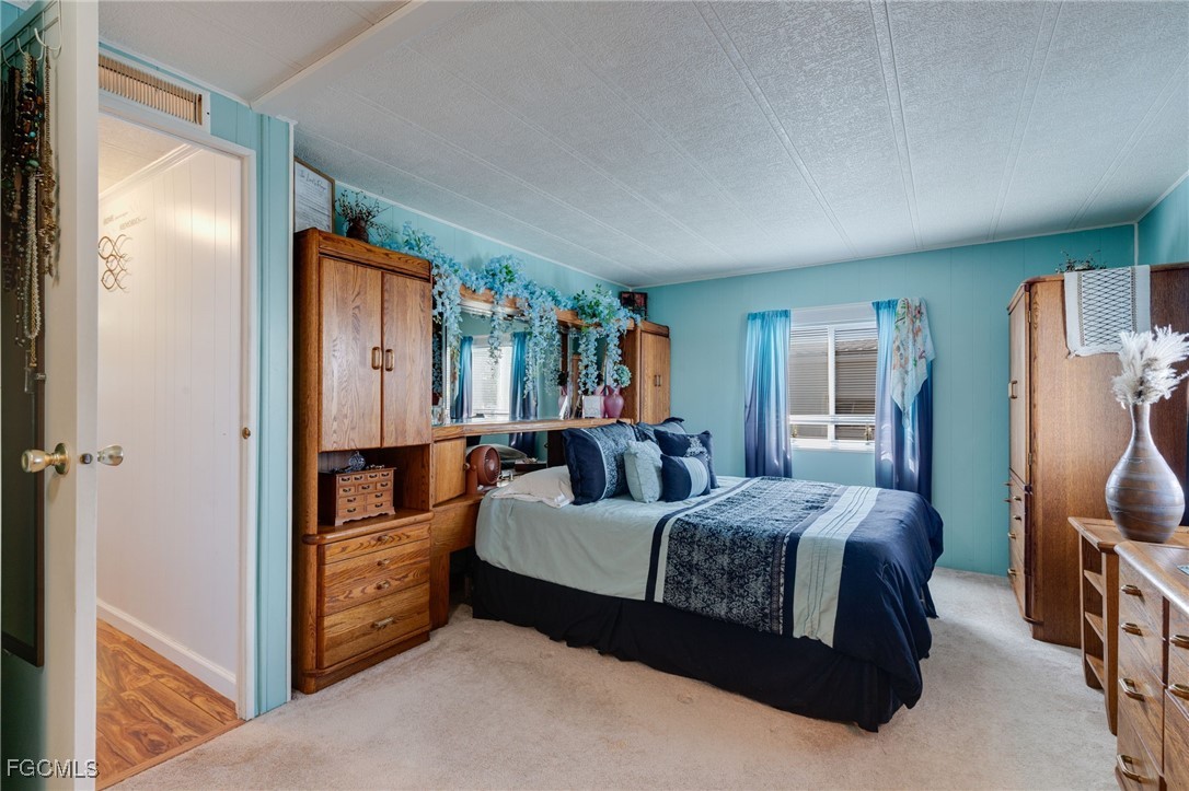 9324 Baron Road Bonita Springs, FL 34135 - Photo 13 of 22 a spacious bedroom with a bed and wooden floor