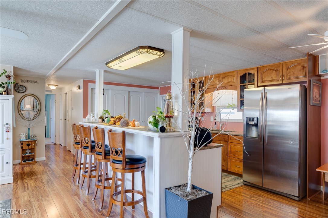 9324 Baron Road Bonita Springs, FL 34135 - Photo 6 of 22 a kitchen with stainless steel appliances granite countertop a refrigerator a stove and a dining table with wooden floor