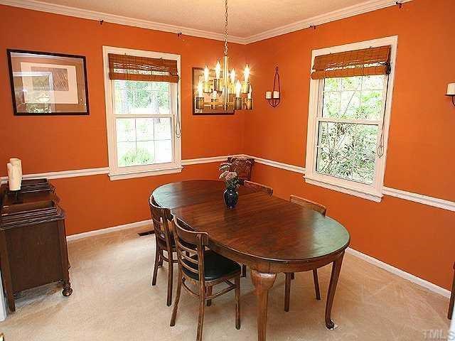 Enjoy this inviting dining room with warm colored walls.