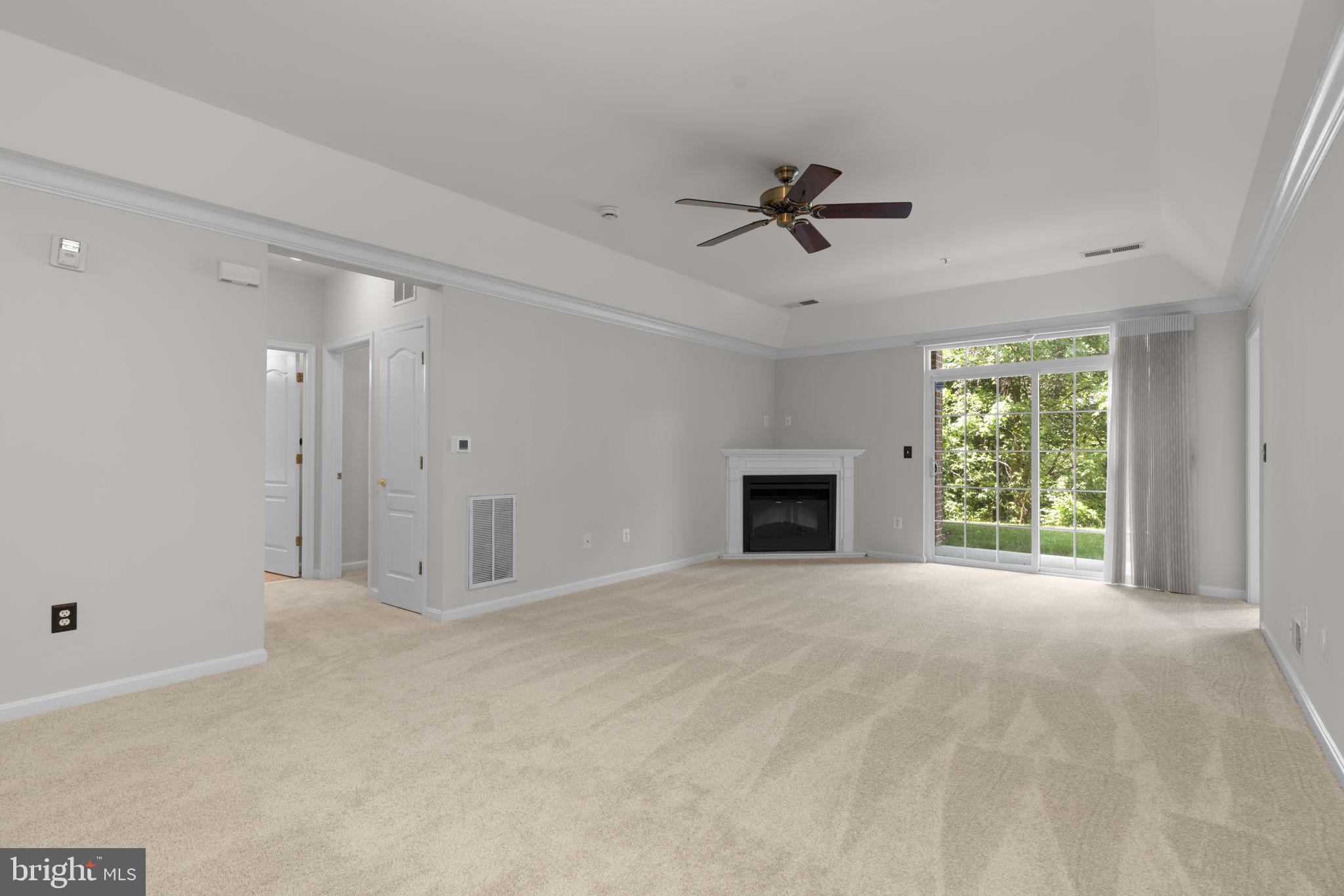 7315 Maplecrest Road, Unit 104 Elkridge, MD 21075 - Photo 12 of 58 a view of an empty room with a fireplace and a window