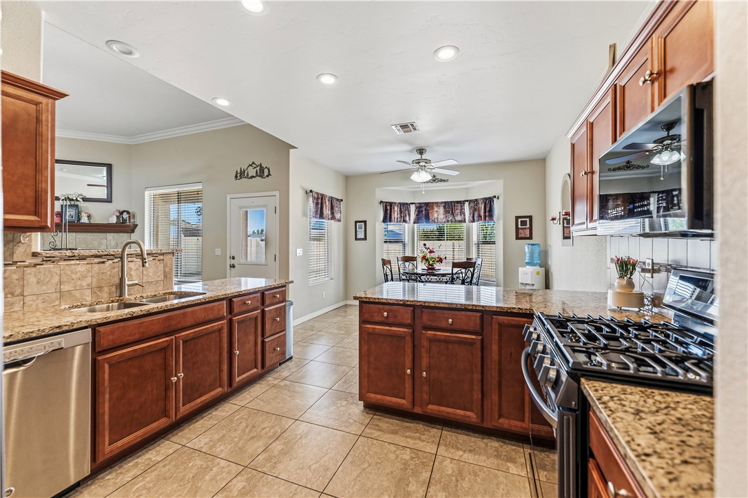 4143 North Stampede Road Kingman, AZ 86401 - Photo 12 of 42 Spacious kitchen featuring warm wood cabinetry, granite countertops, and tile flooring