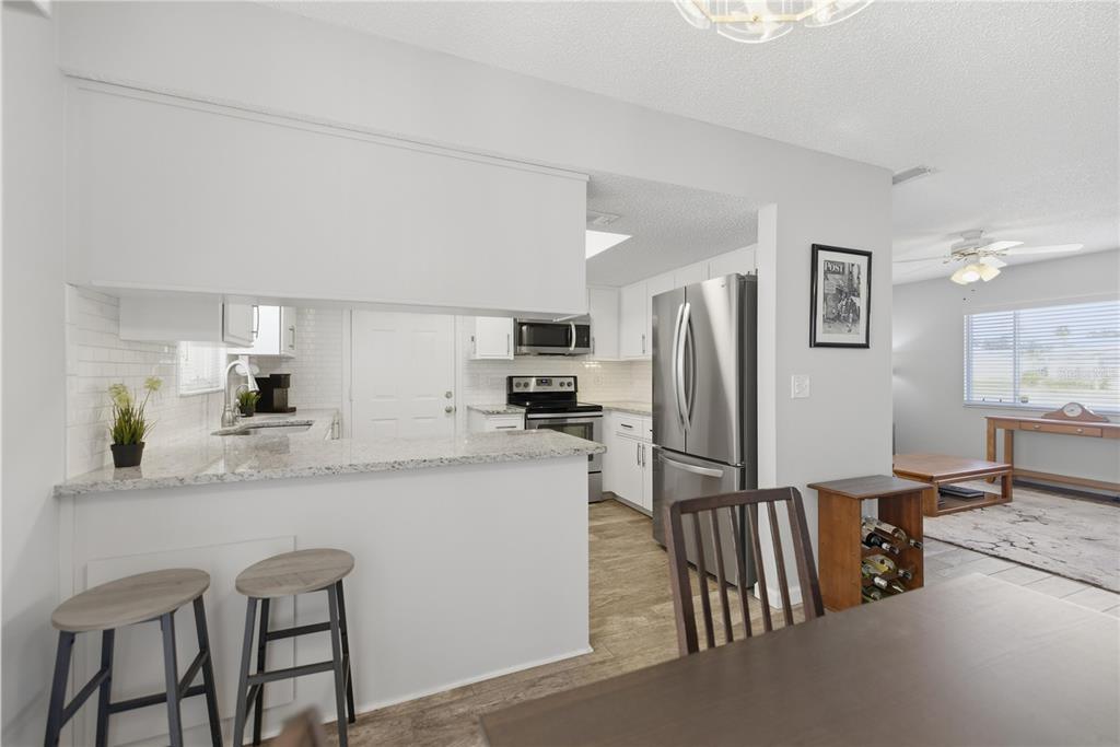 10492 Southeast 178th Street Summerfield, FL 34491 - Photo 12 of 32 a kitchen with stainless steel appliances granite countertop a refrigerator and microwave