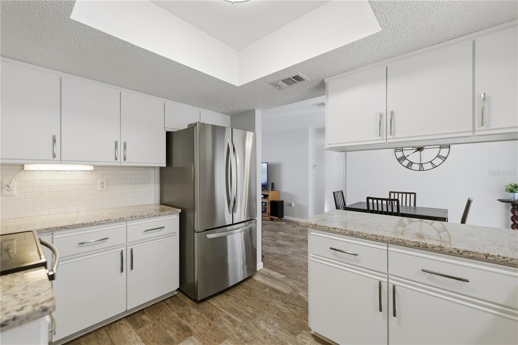 10492 Southeast 178th Street Summerfield, FL 34491 - Photo 14 of 32 a kitchen with granite countertop cabinets and refrigerator