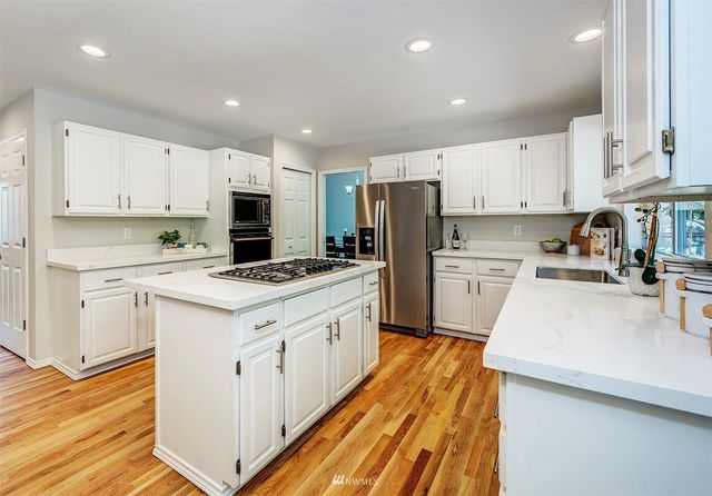 a kitchen with granite countertop white cabinets and white appliances