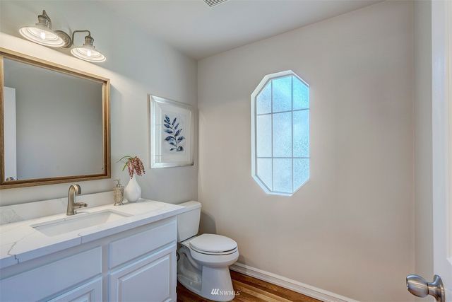 a bathroom with a toilet a sink and mirror