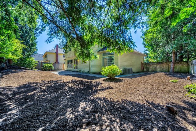 a front view of a house with a yard and tree