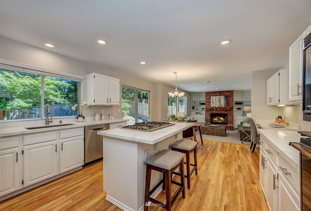 a kitchen with a sink a stove a refrigerator cabinets and wooden floor