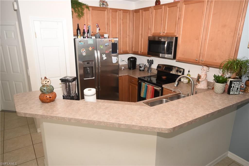 11738 Eros Road Lehigh Acres, FL 33971 - Photo 5 of 42 a kitchen with a refrigerator and a stove