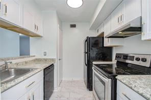 17331 Red Oak Drive, Unit 45 Houston, TX 77090 - Photo 11 of 25 a kitchen with granite countertop a sink stove and cabinets