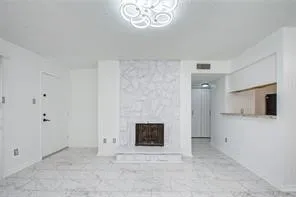 a view of an empty room with a fireplace and a window