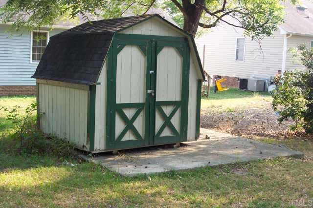 1514 Joe Louis Avenue Raleigh, NC 27610 - Photo 4 of 8 a view of a wooden house with a yard and large tree