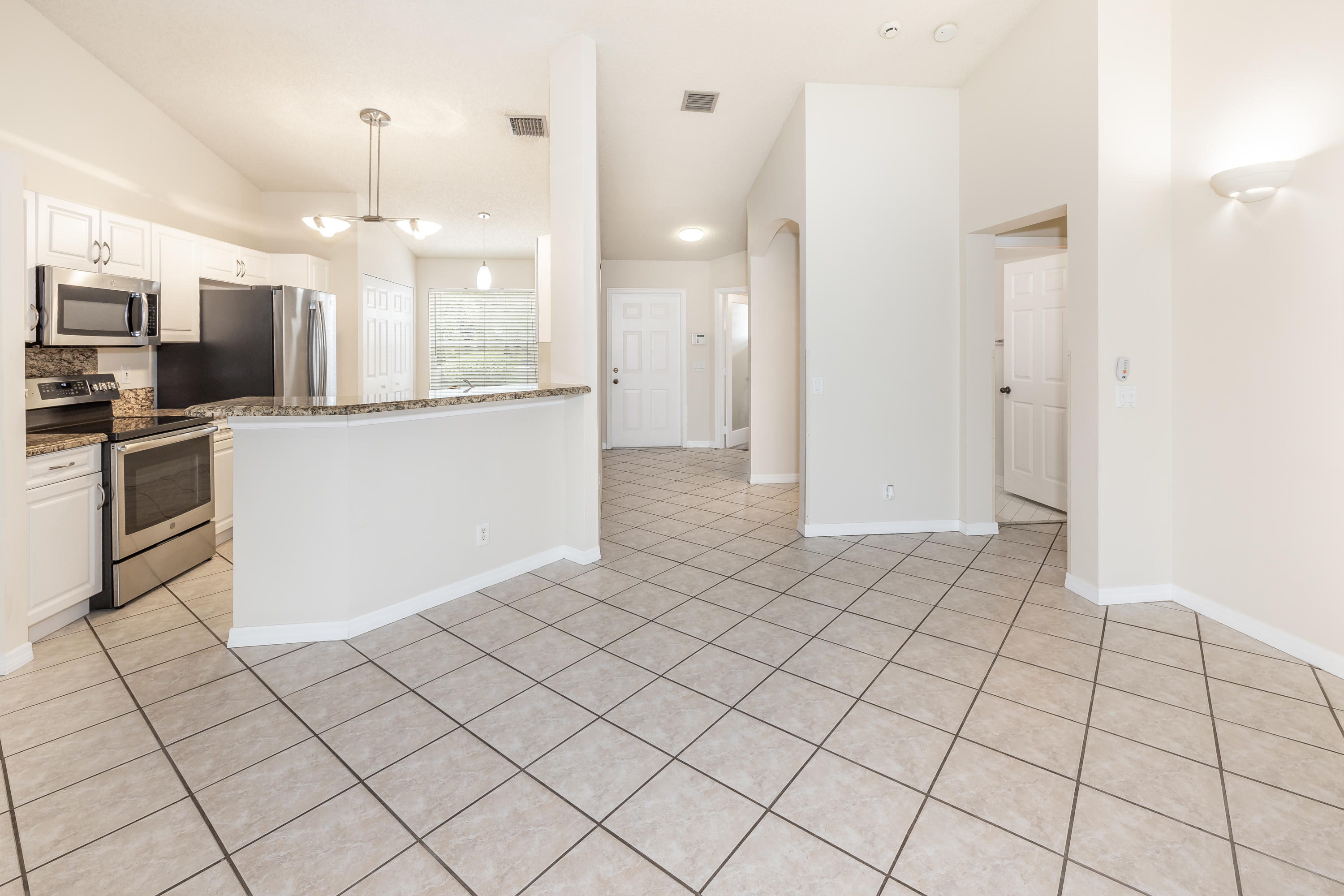 4244 Pine Ridge Court Weston, FL 33331 - Photo 12 of 34 a kitchen with stainless steel appliances kitchen island granite countertop a refrigerator and a stove top oven