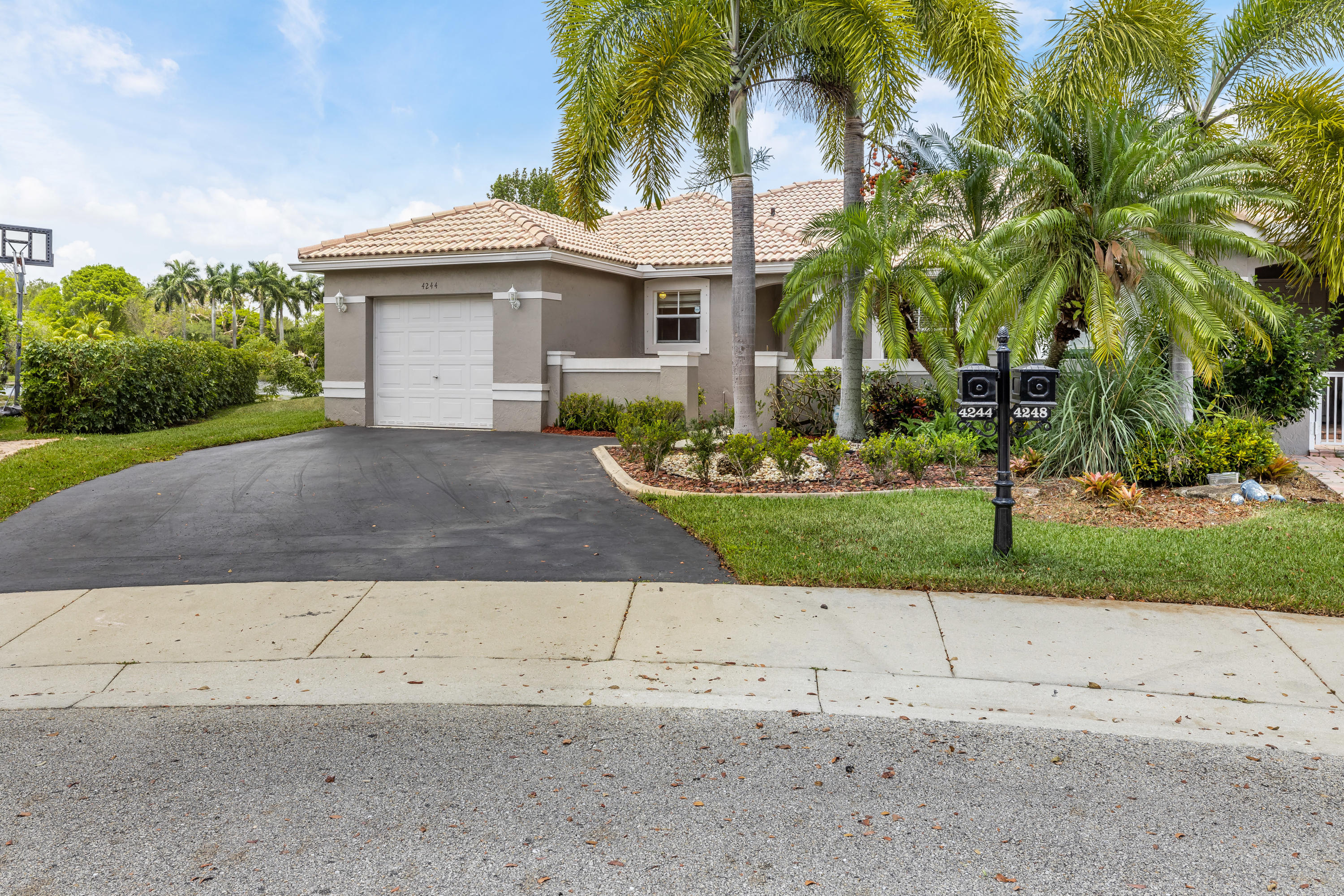 4244 Pine Ridge Court Weston, FL 33331 - Photo 3 of 34 a front view of a house with a yard and a garage