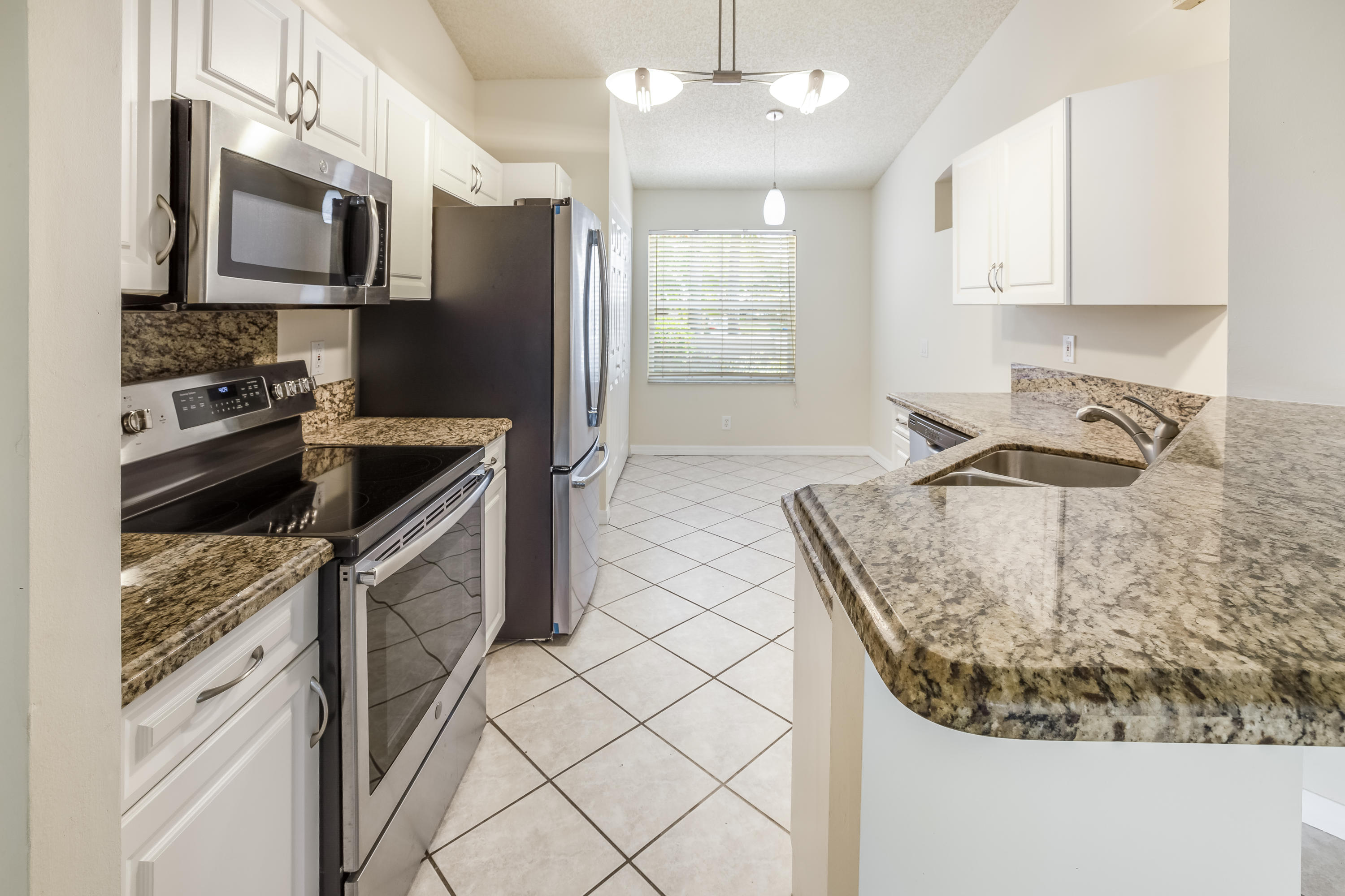 4244 Pine Ridge Court Weston, FL 33331 - Photo 5 of 34 a kitchen with stainless steel appliances granite countertop a sink stove and refrigerator