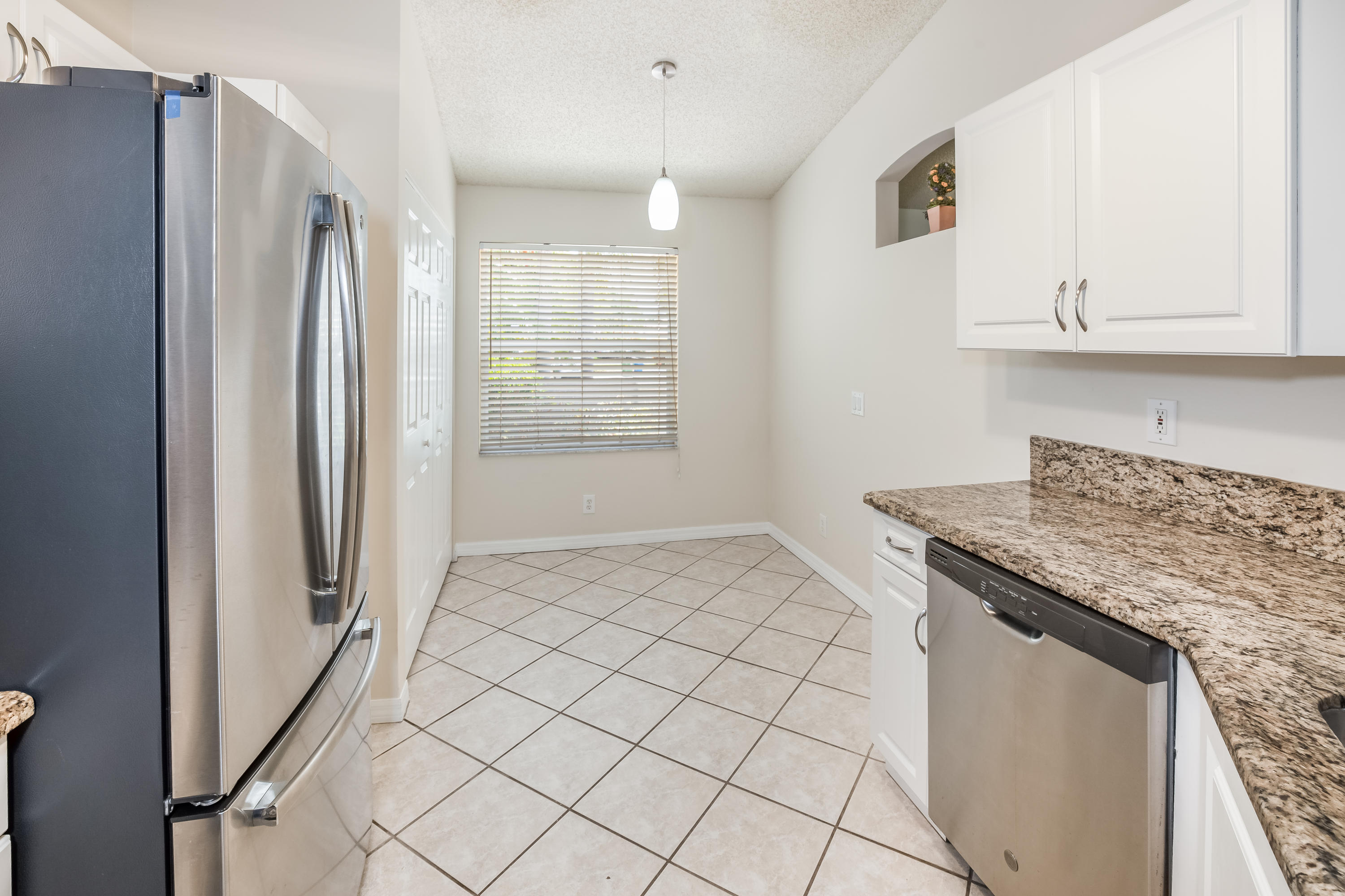 4244 Pine Ridge Court Weston, FL 33331 - Photo 7 of 34 a kitchen with granite countertop a refrigerator and a stove