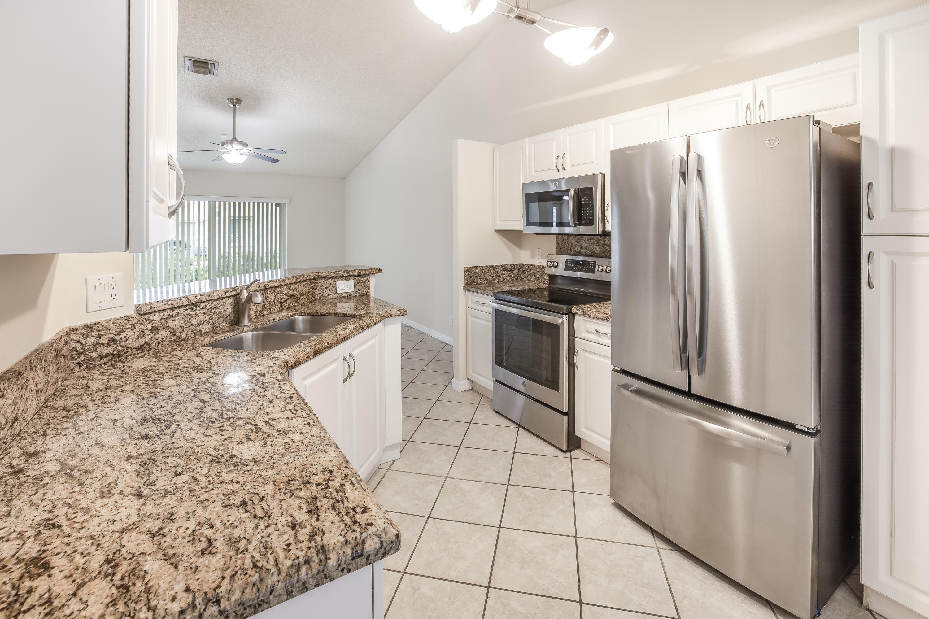 4244 Pine Ridge Court Weston, FL 33331 - Photo 9 of 34 a kitchen with granite countertop a refrigerator and a sink