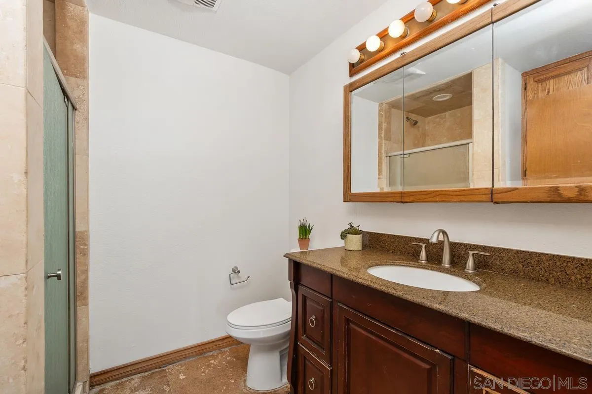 15918 Lime Grove Road Poway, CA 92064 - Photo 36 of 53 a bathroom with a granite countertop sink toilet and mirror