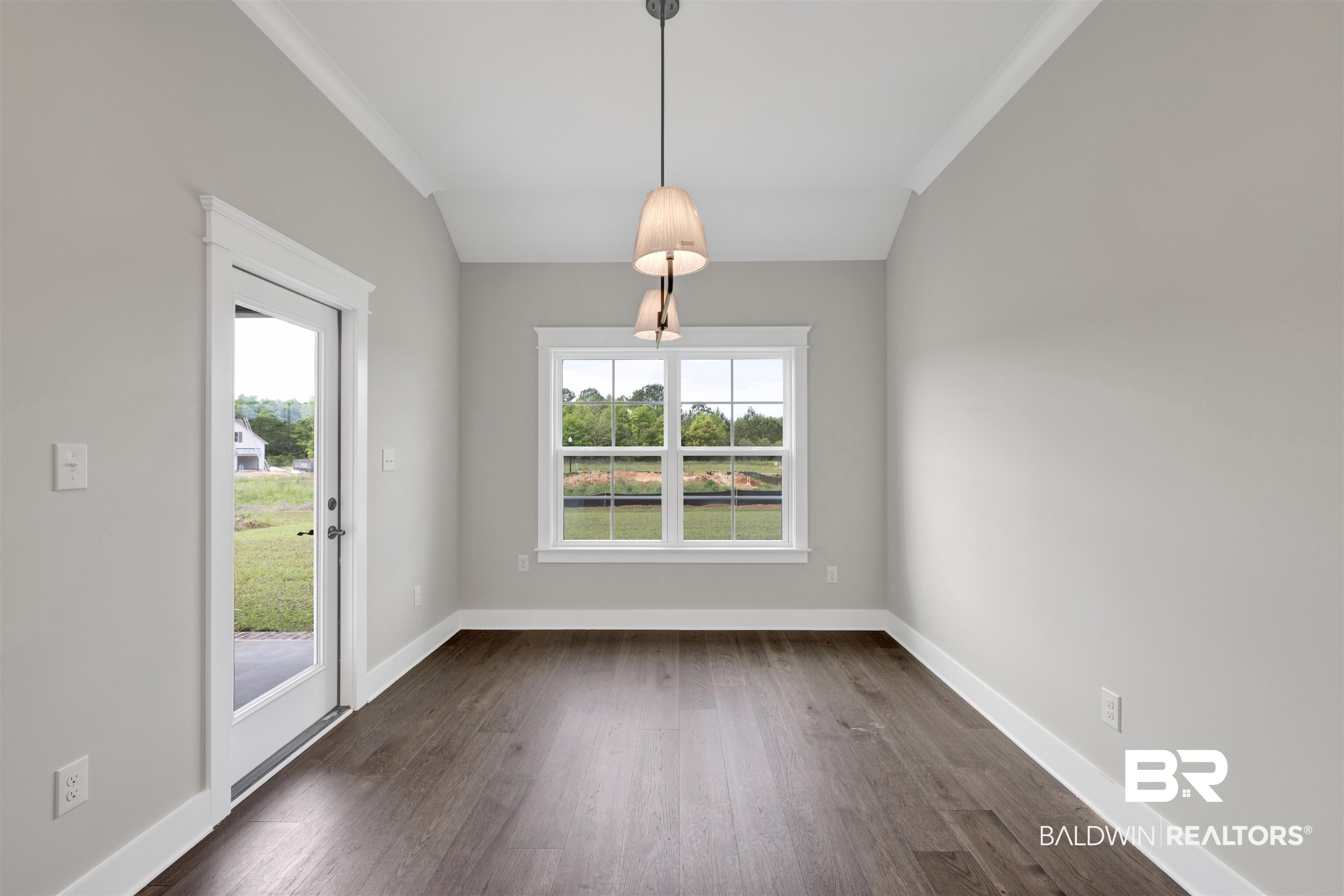 27315 Patch Pl Loop Daphne, AL 36526 - Photo 12 of 43 Unfurnished dining area with lofted ceiling, dark wood-style flooring, plenty of natural light, and crown molding