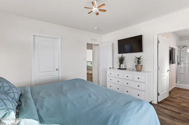 a bedroom with a large bed and a flat tv screen