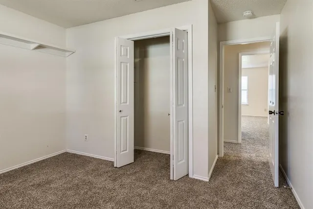 an empty room that has a glass door and closet