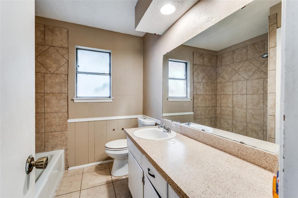 2102 East Timberview Lane Arlington, TX 76014 - Photo 3 of 10 a bathroom with a granite countertop sink a toilet and shower