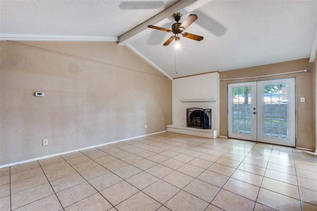 2102 East Timberview Lane Arlington, TX 76014 - Photo 8 of 10 a view of an empty room with a fireplace and a chandelier fan