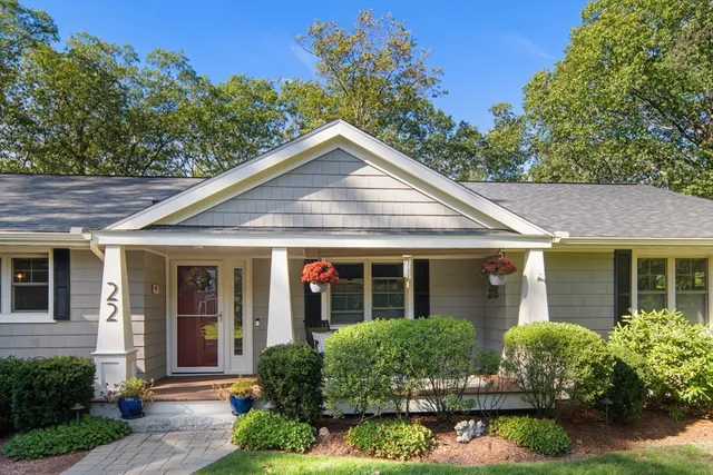 a front view of a house with a yard and potted plants