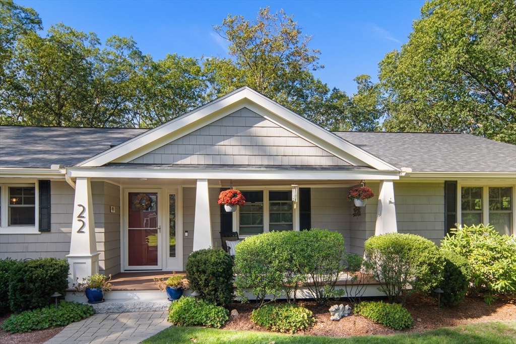 a front view of a house with a yard and potted plants