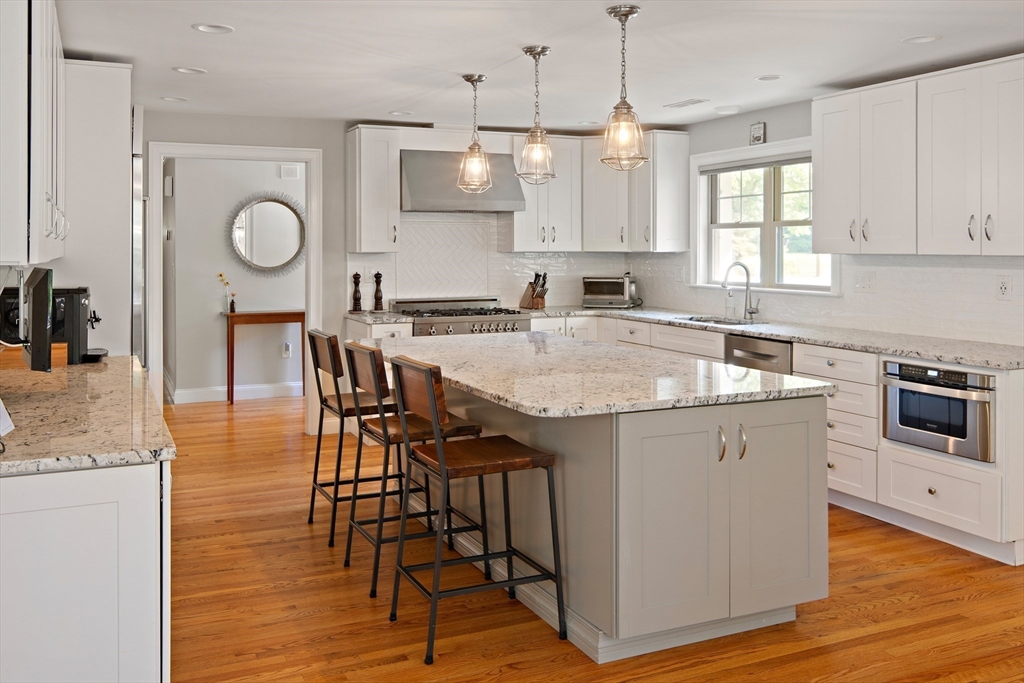 22 Peachtree Road Lexington, MA 02420 - Photo 7 of 42 a kitchen with granite countertop a table chairs stove and cabinets
