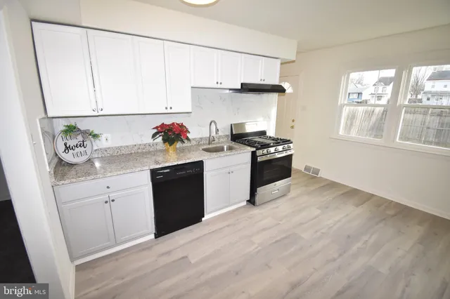 a kitchen with a sink stove and white cabinets