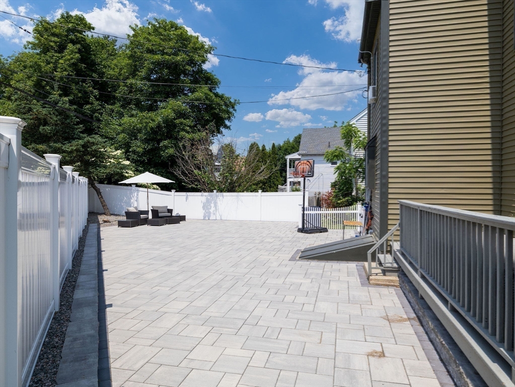 168 Maple Street Boston, MA 02132 - Photo 16 of 39 a view of a patio with a table and chairs next to a yard