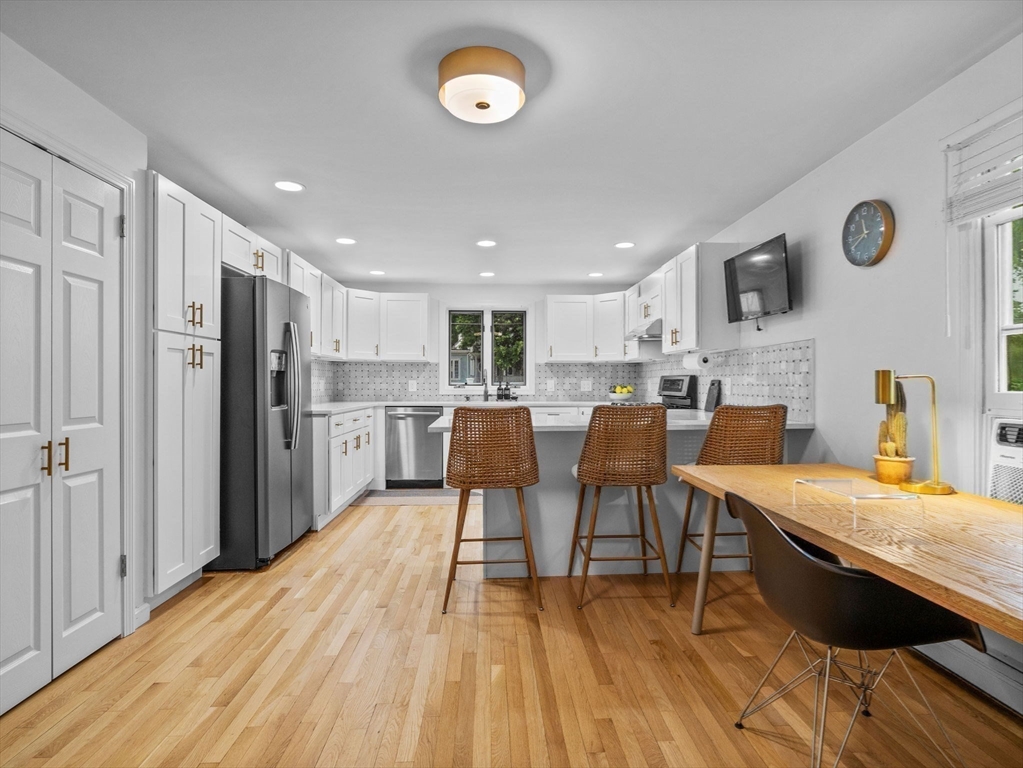 168 Maple Street Boston, MA 02132 - Photo 6 of 39 a open kitchen with stainless steel appliances granite countertop a stove refrigerator and a dining table with wooden floor