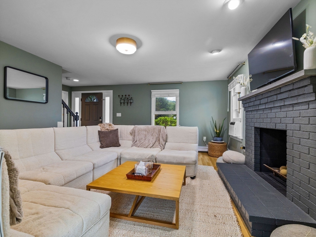 168 Maple Street Boston, MA 02132 - Photo 10 of 39 a living room with furniture and a fireplace