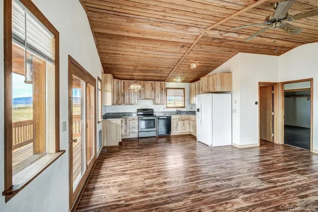 a kitchen with stainless steel appliances a refrigerator and wooden floor