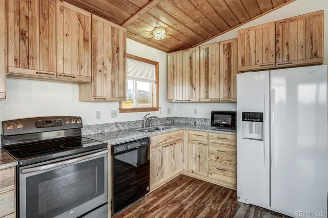 a kitchen with stainless steel appliances granite countertop a stove a refrigerator and a cabinets