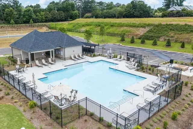 a view of a house with pool and a yard
