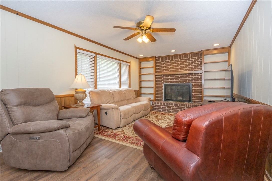 1116 Leatherdale Road Iva, SC 29655 - Photo 10 of 46 This inviting living area features a charming fireplace, built-in shelving, and warm wood flooring.