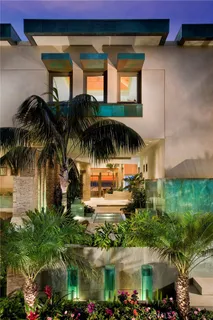 a view of a swimming pool with potted plants and palm tree