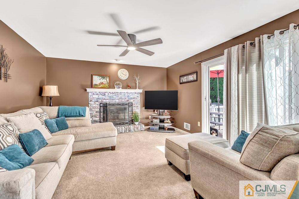 5 Netty Street Howell, NJ 07731 - Photo 16 of 36 a living room with furniture a flat screen tv and a fireplace